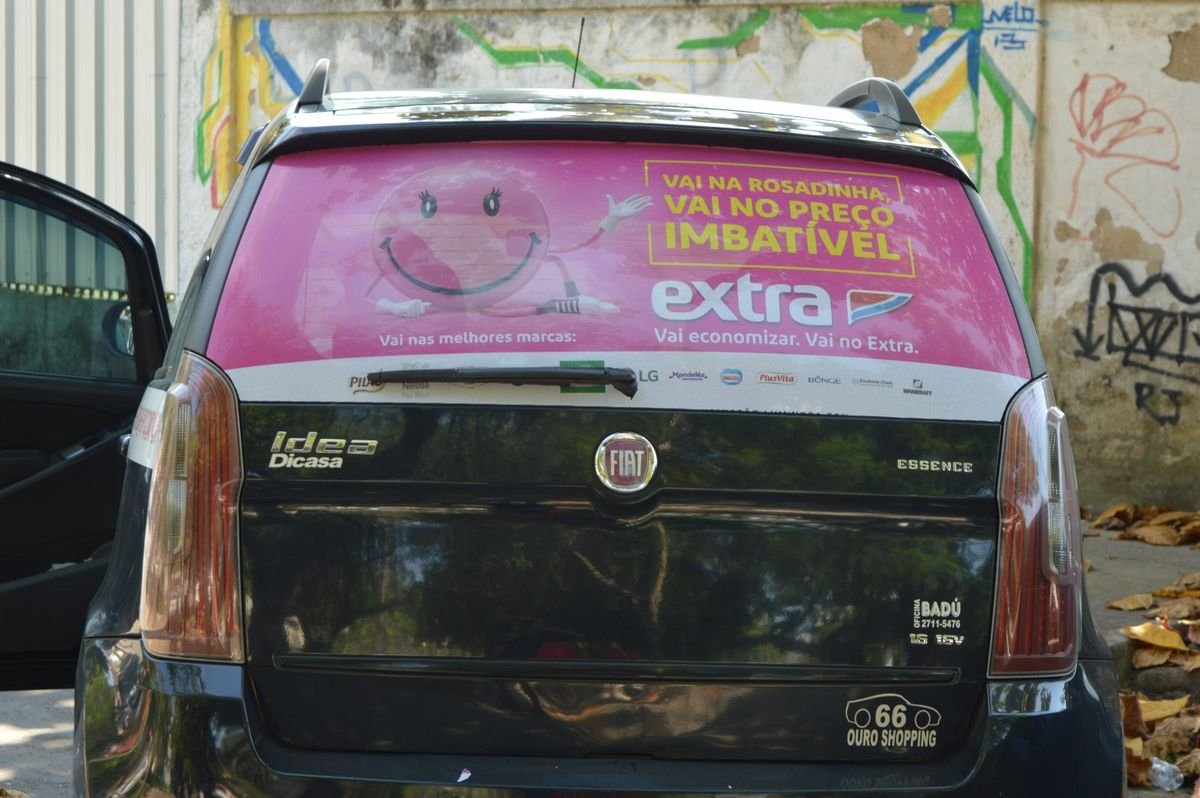 Táxi Fiat Idea em Niterói com Taxidoor do Extra no vidro traseiro